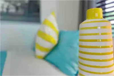 a yellow and white bottle sitting next to two pillows at B01 Minutes from the beach Studio Midtown Wynwood in Miami