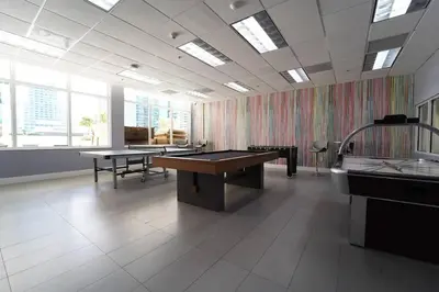 a large room with ping pong tables and windows at 2 bed condo, Queen sofa bed Brickell, Free Parking, Pool, Gym in Miami
