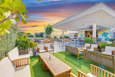 an outdoor patio with tables and chairs and a sunset at Rooftop Pool Balcony Hollywood Beach Broad walk in Hollywood