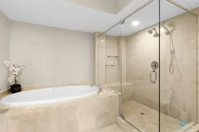 a bathroom with a tub and a glass shower at Luxury High Resort Beautiful Views & Amenities in Hallandale Beach
