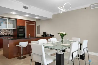a dining room with a table and white chairs at Luxury High Resort Beautiful Views & Amenities in Hallandale Beach