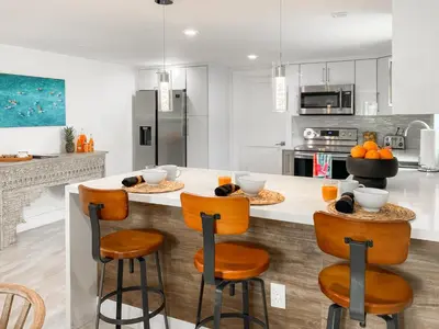 a kitchen with a large island with bar stools at Villa Palma - Prime Location, Pool, Game Room, Outdoor Kitchen in Miami