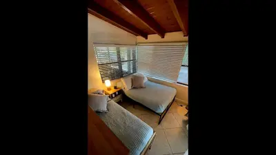 a living room with a couch and a table and a window at Pool House Resort heated swimming pool private duplex in Cutler Bay