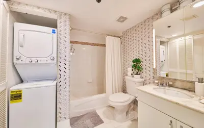 a bathroom with a toilet and a tub and a sink at Serene View 1 BR in Miami