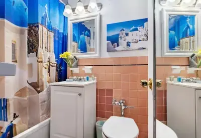 a bathroom with a toilet and two sinks and a shower at The Plaza Miami Beach in Miami Beach