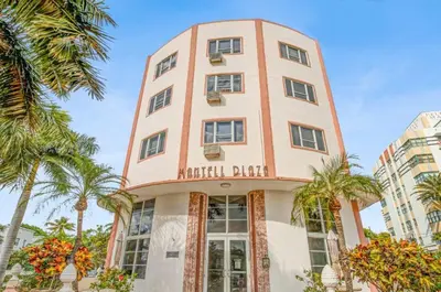 a tall building with palm trees in front of it at The Plaza Miami Beach in Miami Beach