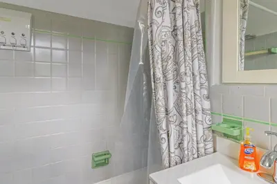 a bathroom with a shower curtain and a sink at The Plaza Miami Beach in Miami Beach