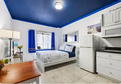 a bedroom with a bed and a blue ceiling at The Plaza Miami Beach in Miami Beach