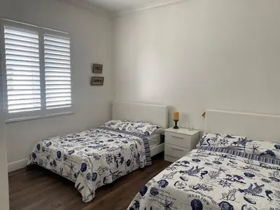 a bedroom with two beds and a window at Paradise Pool House in Dania in Dania Beach