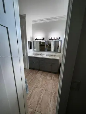 a bathroom with a sink and a mirror at Paradise Pool House in Dania in Dania Beach