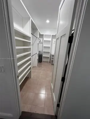 a hallway with white shelves and a tile floor at Paradise Pool House in Dania in Dania Beach