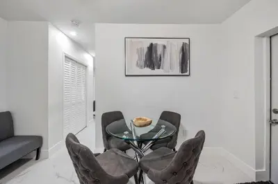 a dining room with a glass table and chairs at Cozy Apartment with a luxury King Bed in Miami Gardens