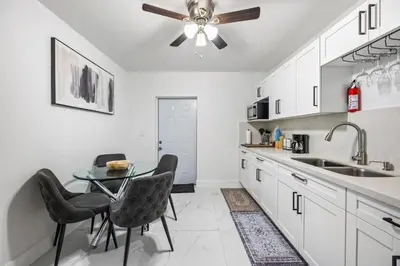a kitchen with a table and chairs and a ceiling fan at Cozy Apartment with a luxury King Bed in Miami Gardens