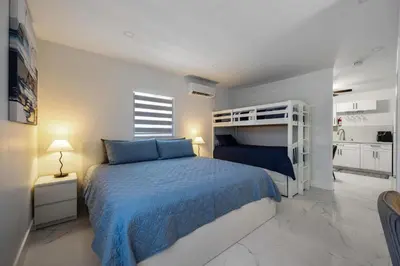 a bedroom with a bed and a bunk bed at Cozy Apartment with a luxury King Bed in Miami Gardens