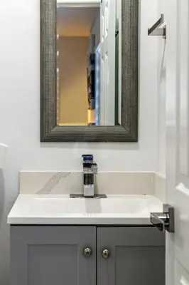 a bathroom with a white sink and a mirror at Cozy Apartment with a luxury King Bed in Miami Gardens