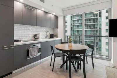 a kitchen with a table and chairs and a large window at NEW Luxury Downtown Apartment - Gym Pool Workspace in Miami