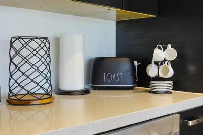 a kitchen counter with a toaster and cups and a vase at Ocean Drive apartment w Balcony Walk to the Beach in Miami Beach