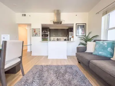 a living room with a couch and a kitchen at Ocean Drive apartment w Balcony Walk to the Beach in Miami Beach