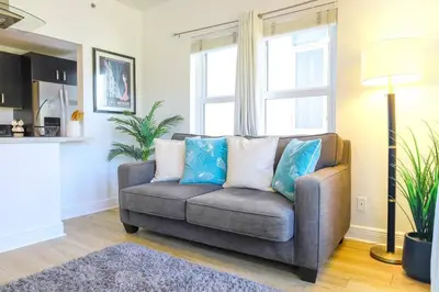 a living room with a couch with blue pillows at Ocean Drive apartment w Balcony Walk to the Beach in Miami Beach