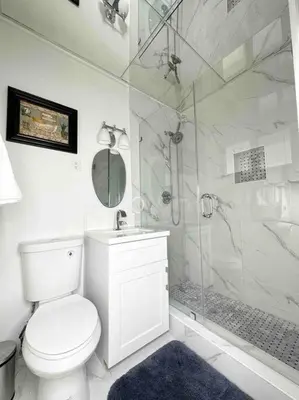 a white bathroom with a shower and a toilet at Villa Bethesda in Miami
