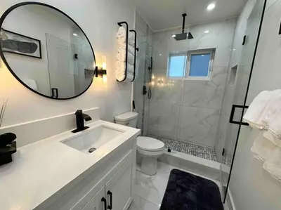 a bathroom with a toilet and a sink and a mirror at Villa Bethesda in Miami