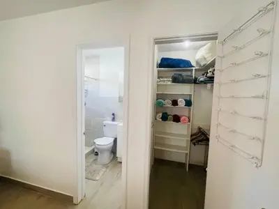 a bathroom with a toilet and a closet with a door at Bright & Cozy Family Home Near Dania Beach in Dania Beach