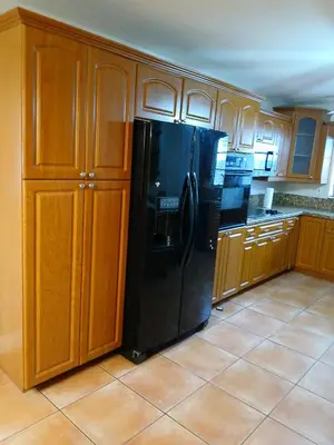a kitchen with a black refrigerator and wooden cabinets at Beautiful Miami Home in Miami