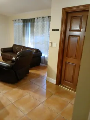 a living room with a leather couch and a door at Beautiful Miami Home in Miami