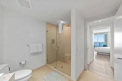 a white bathroom with a shower and a toilet at Oceanfront Luxury Condo With WaterView in Hollywood