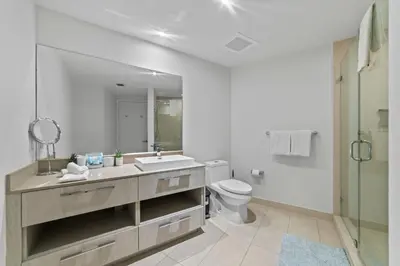a white bathroom with a sink and a toilet at Oceanfront Luxury Condo With WaterView in Hollywood