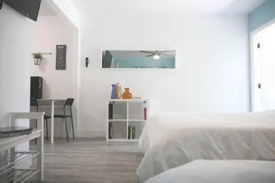 a bedroom with two beds and a table and a mirror at B02 5 min from beach studio Midtown Wynwood in Miami