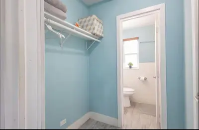 a bathroom with a toilet and a blue wall at B02 5 min from beach studio Midtown Wynwood in Miami