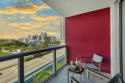 a balcony with a red wall and a view of the city at Amazing Studio Beautifull View Balcony Pool Gym in Hallandale Beach