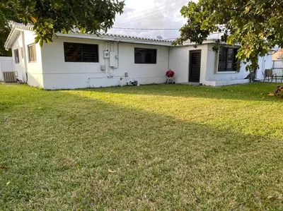 a white house with a lawn in front of it at Luxurious Westchester Home Near Miami Clinics in Miami