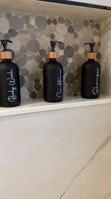 three black bottles sitting on a shelf in a bathroom at Luxurious Westchester Home Near Miami Clinics in Miami