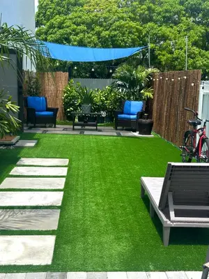 a yard with green grass and blue chairs at Tropical Studio in Miami