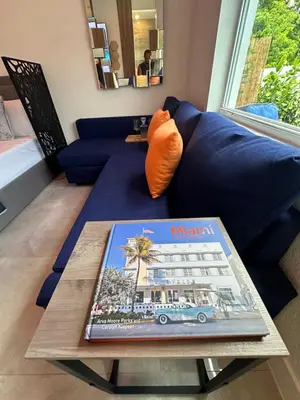 a living room with a blue couch and a table at Tropical Studio in Miami