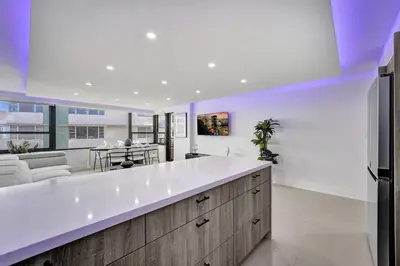 a kitchen with a large white counter and a living room at Amazing 3 bedrooms 3 bathrooms Beach Resort 1518 in Miami Beach