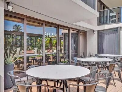 an outdoor patio with tables and chairs and windows at Amazing 3 bedrooms 3 bathrooms Beach Resort 1518 in Miami Beach