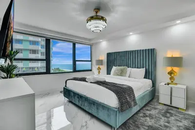 a bedroom with a large bed and a large window at Ocean View Condo Beach Service 808 in Miami Beach