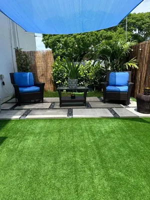 a yard with green grass and two chairs and a table at Tropical Studio in Miami