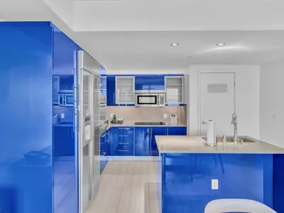 a blue kitchen with stainless steel appliances and blue cabinets at FLL W Residence Penthouse, AMAZING birds eye views! in Fort Lauderdale