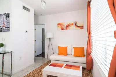 a living room with orange pillows on a couch at 1Bedroom Collins 2 Blocks to Ocean with Paid Street Parking in Miami Beach
