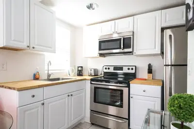 a kitchen with white cabinets and a stove and microwave at 1Bedroom Collins 2 Blocks to Ocean with Paid Street Parking in Miami Beach