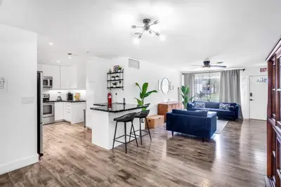 a kitchen and living room with a couch and a table at Spacious 5 Bedroom Heated Pool and Hot Tub, 12 minutes to the Beach in Hollywood