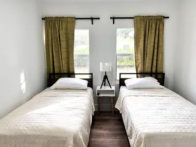two beds in a room with two windows at New 3Bedroom 2Bathroom Private Home in Miami