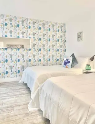 a room with two beds and a wall with flowers at B04 7 minutes from the beach Midtown Miami in Miami