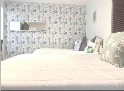 a white bed in a bedroom with a wall at B04 7 minutes from the beach Midtown Miami in Miami