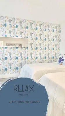 a bedroom with two beds and a floral wall at B04 7 minutes from the beach Midtown Miami in Miami