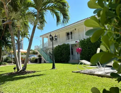 a white house with palm trees and a lawn at B05 Nicest 1 bedroom APT in Midtown Miami in Miami